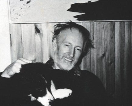 Black and white capture of MacInnes holding a border collie dog